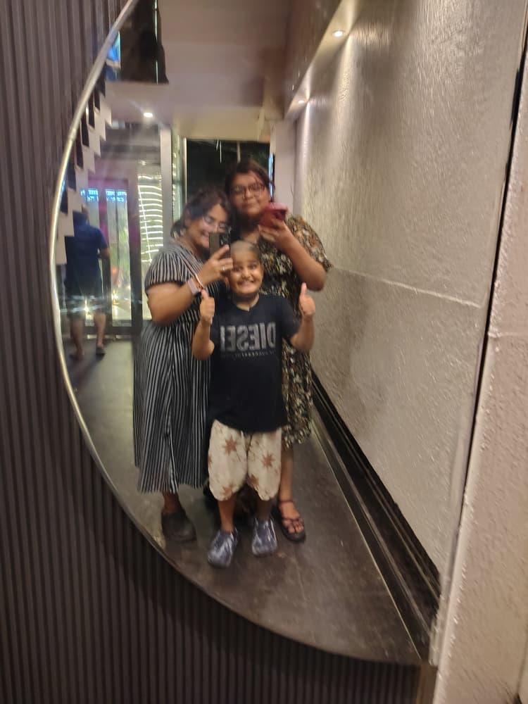 Vyom giving double thumbs up smiling cheerfully in a mirror selfie with family