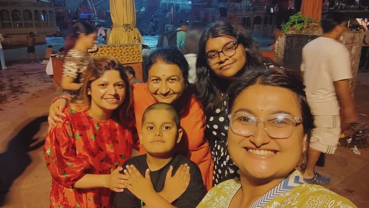 Vyom with hands crossed like a little hero surrounded by his loving family by the river