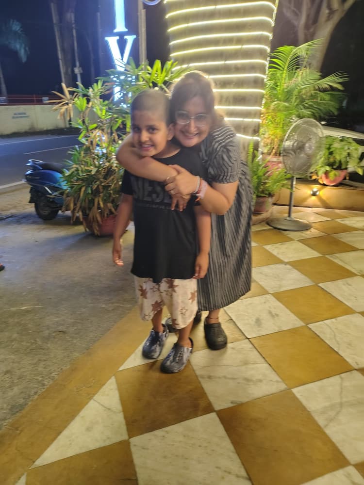 Vyom enjoying warm family hugs outside under festive glowing evening lights