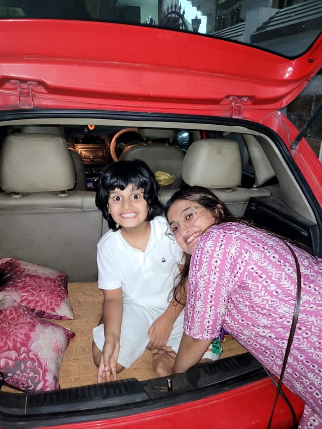 Vyom making funny, expressive faces in the car trunk